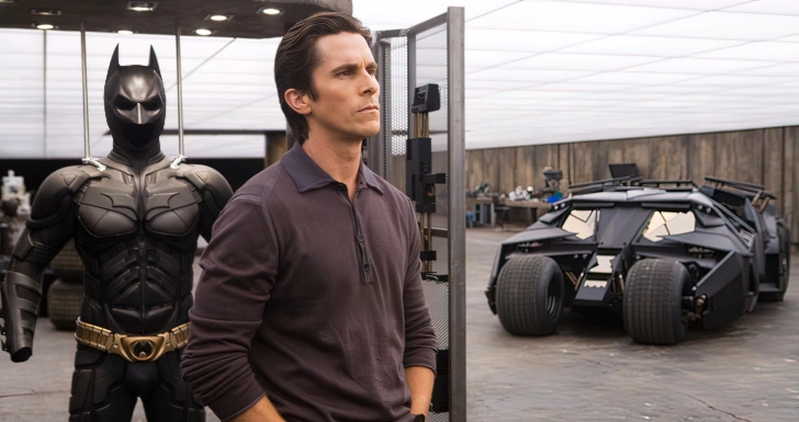 Christian Bale em The Dark Knight ao lado do Batmobile