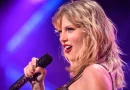 Taylor Swift com um microfone, a cantar uma das músicas da Eras Tour