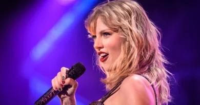 Taylor Swift com um microfone, a cantar uma das músicas da Eras Tour