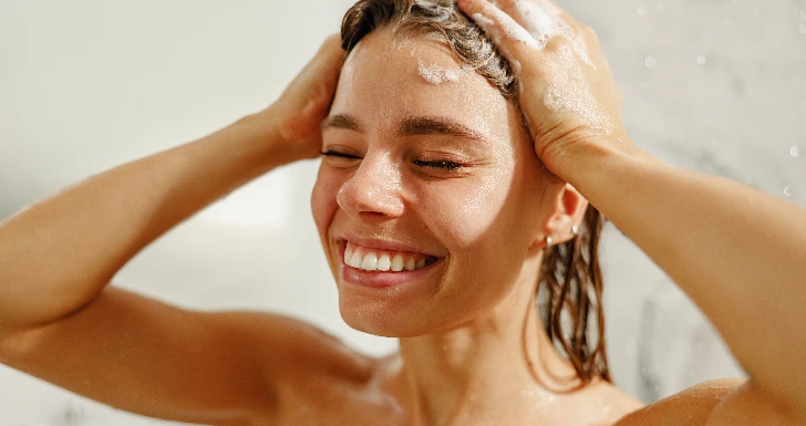 Mulher a usar amaciador no cabelo.